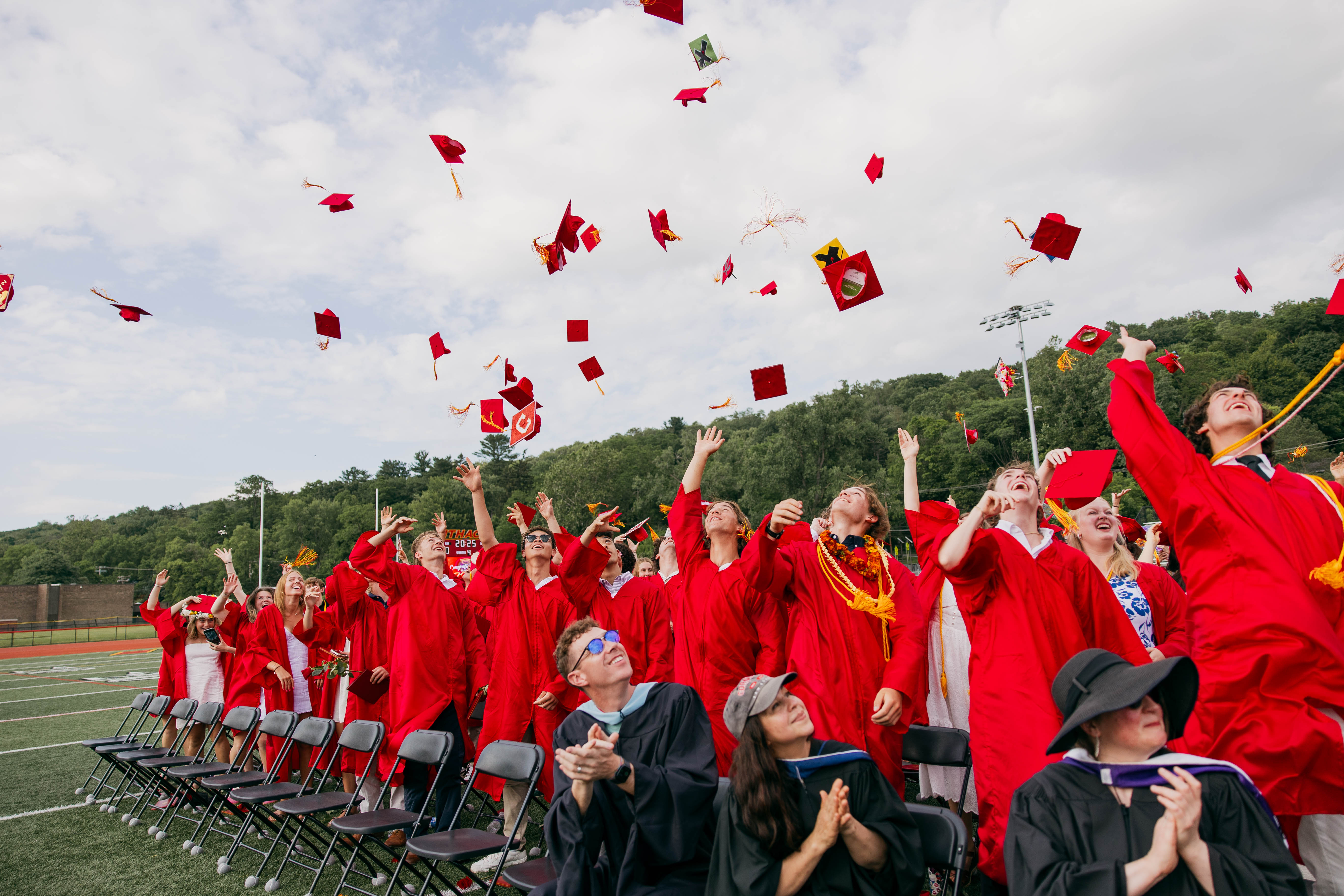 2025 IHS graduates throwing their caps in the air 