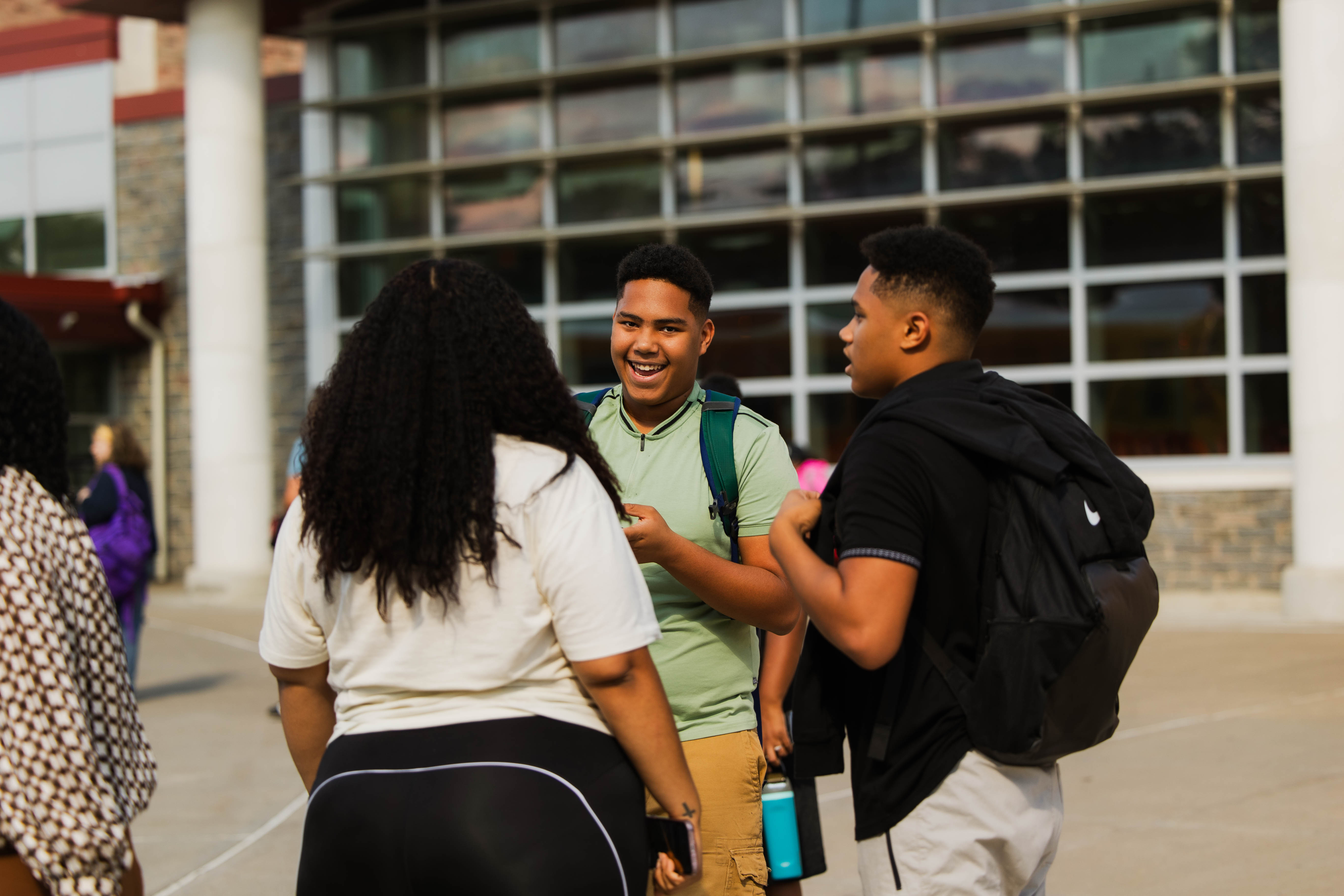 Two Ithaca High students reunite with their school counselor on the first day of school