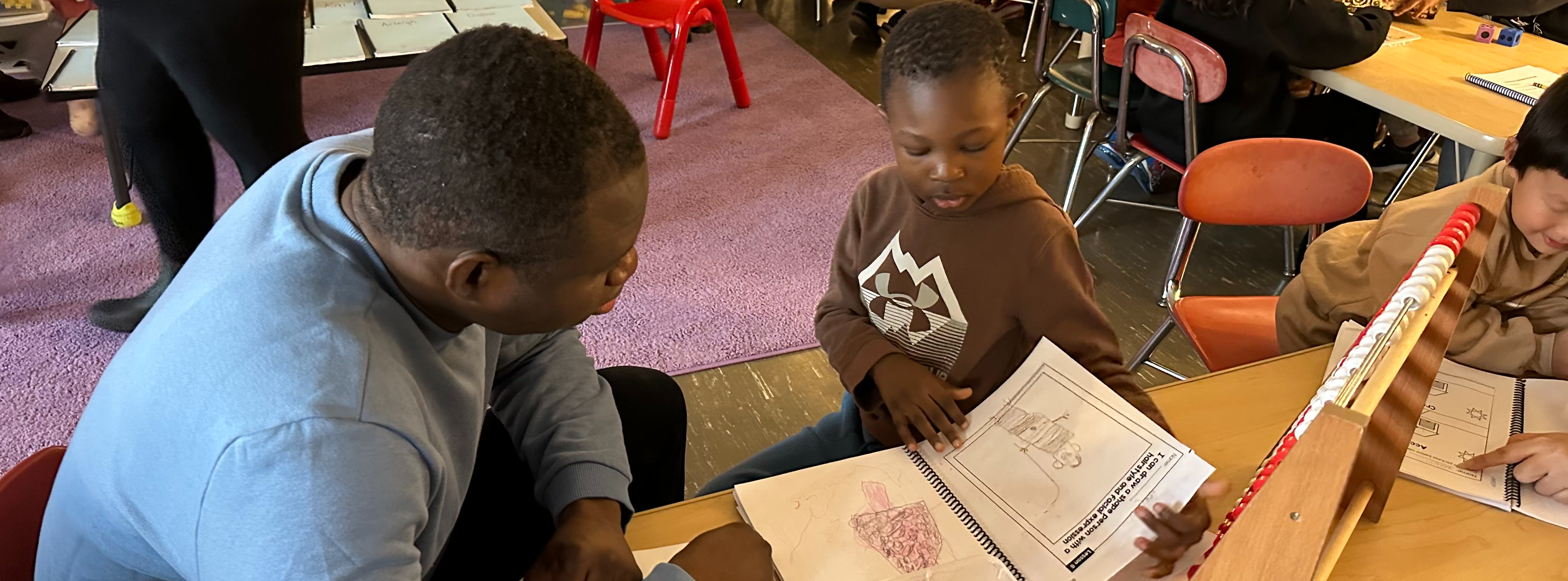 A student sharing their work with a caregiver in a classroom 