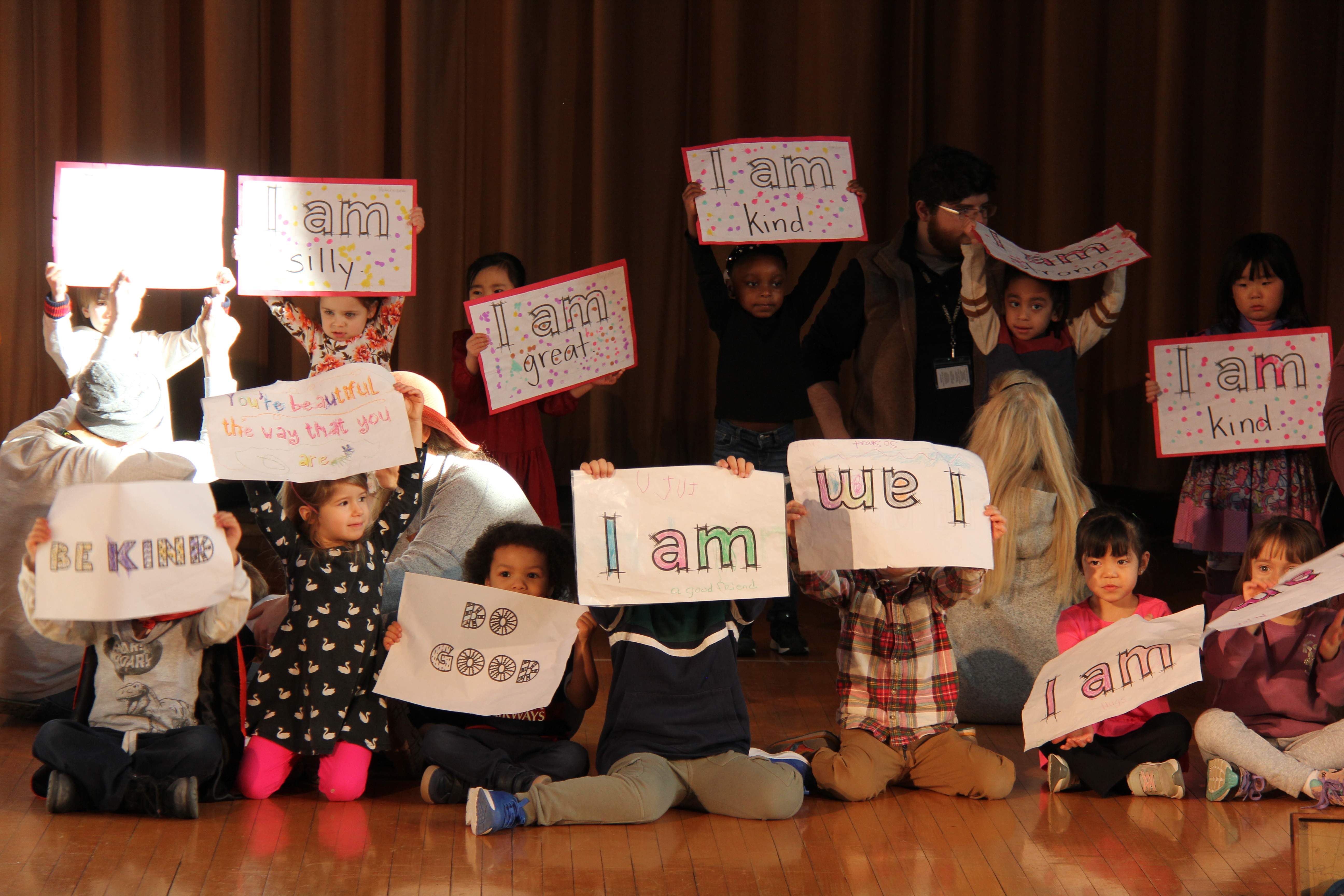 BJM students hold up "I am" signs during all-school assembly