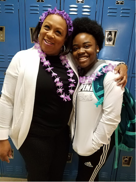 Staff member with arm around student, both smiling