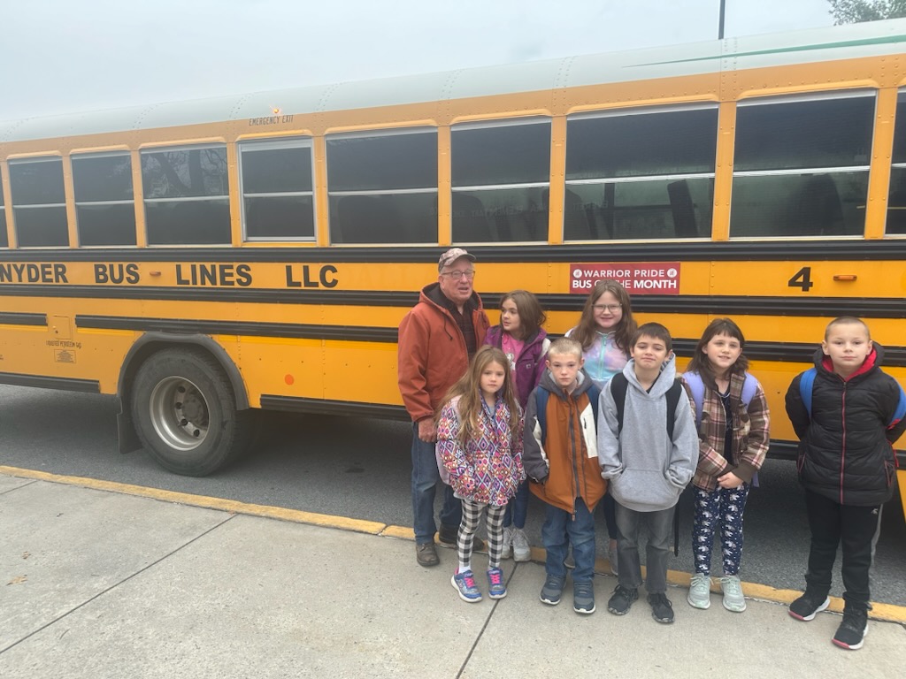 Bus 4 won November bus of the month. Students stand with driver of bus 4 for a picture.