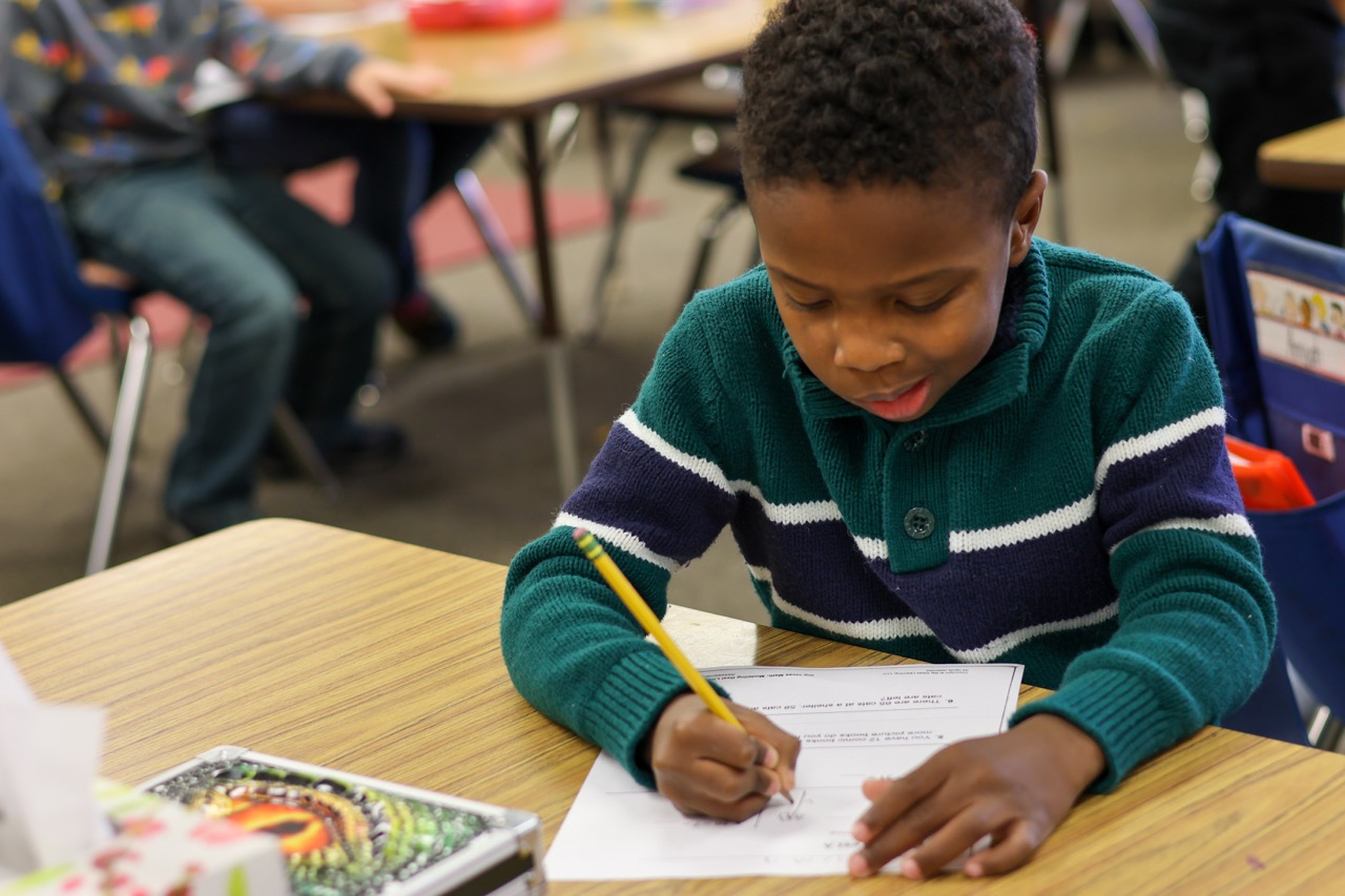 male elementary student writing