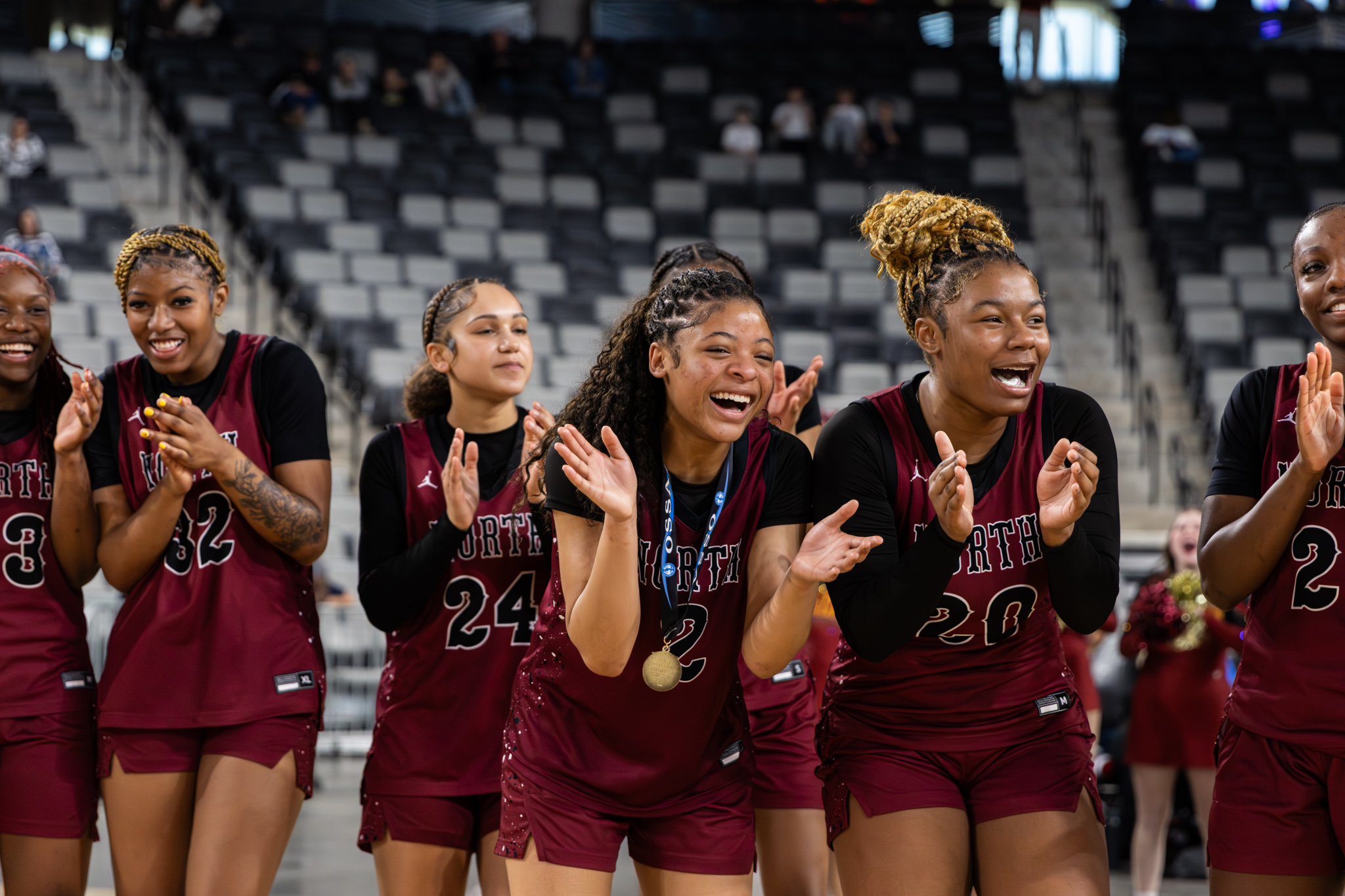 Female basketball players cheering happily and holding medals