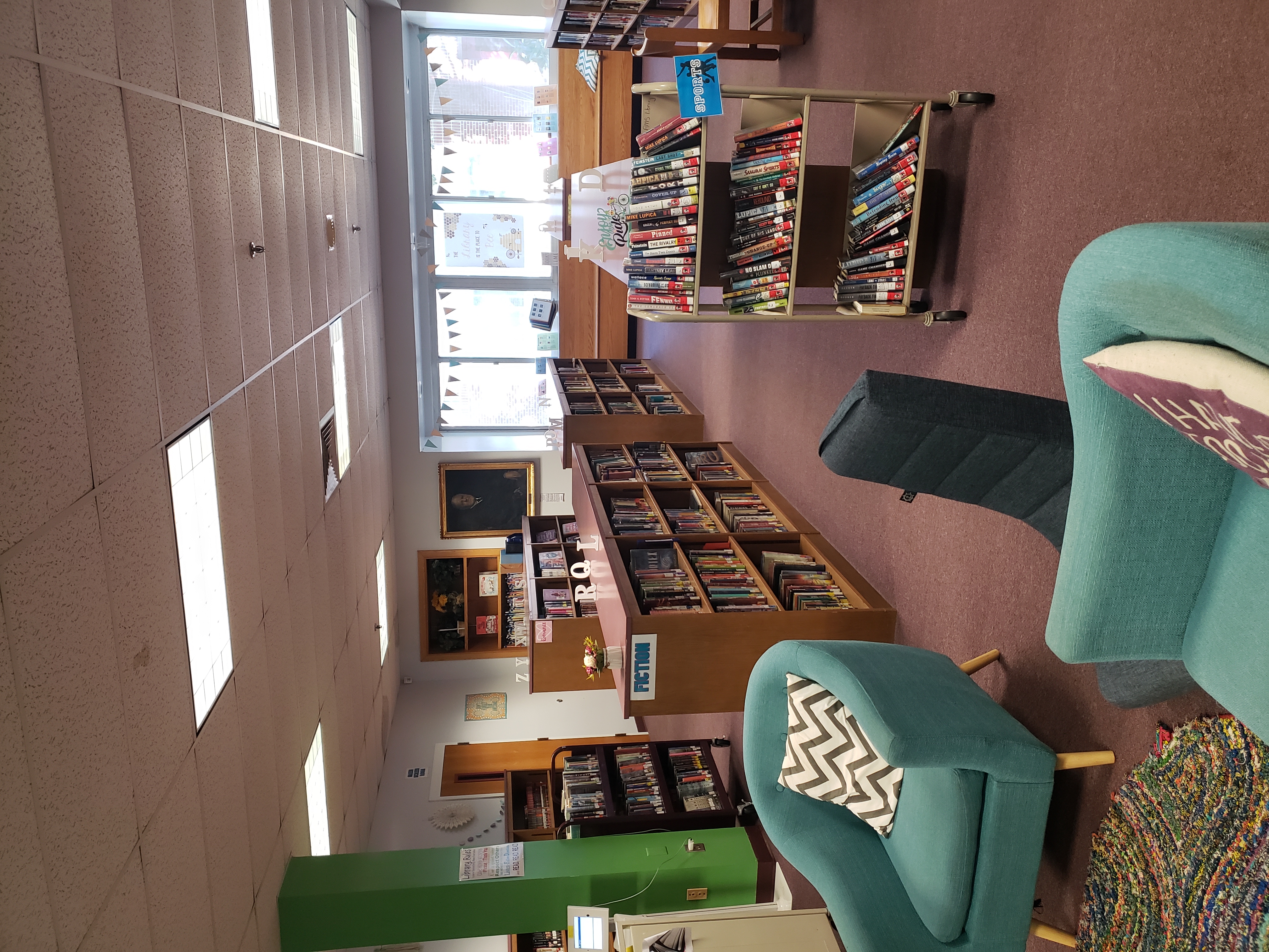 Photo of Library with chairs and rows of bookshelves filled with books