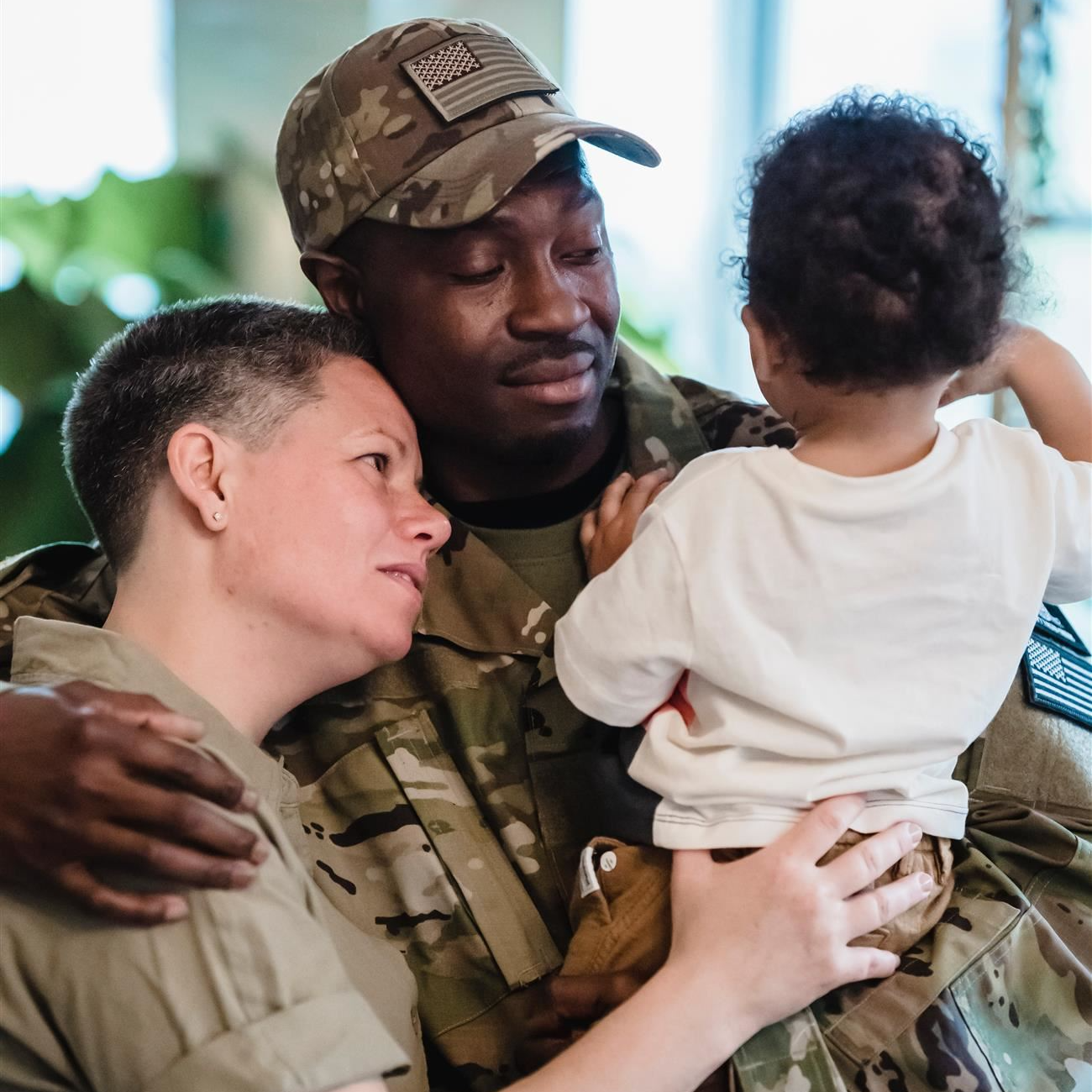 military couple with a baby hugging one another