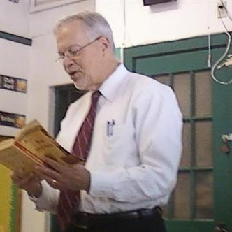 Man reading book in classroom for read aloud day