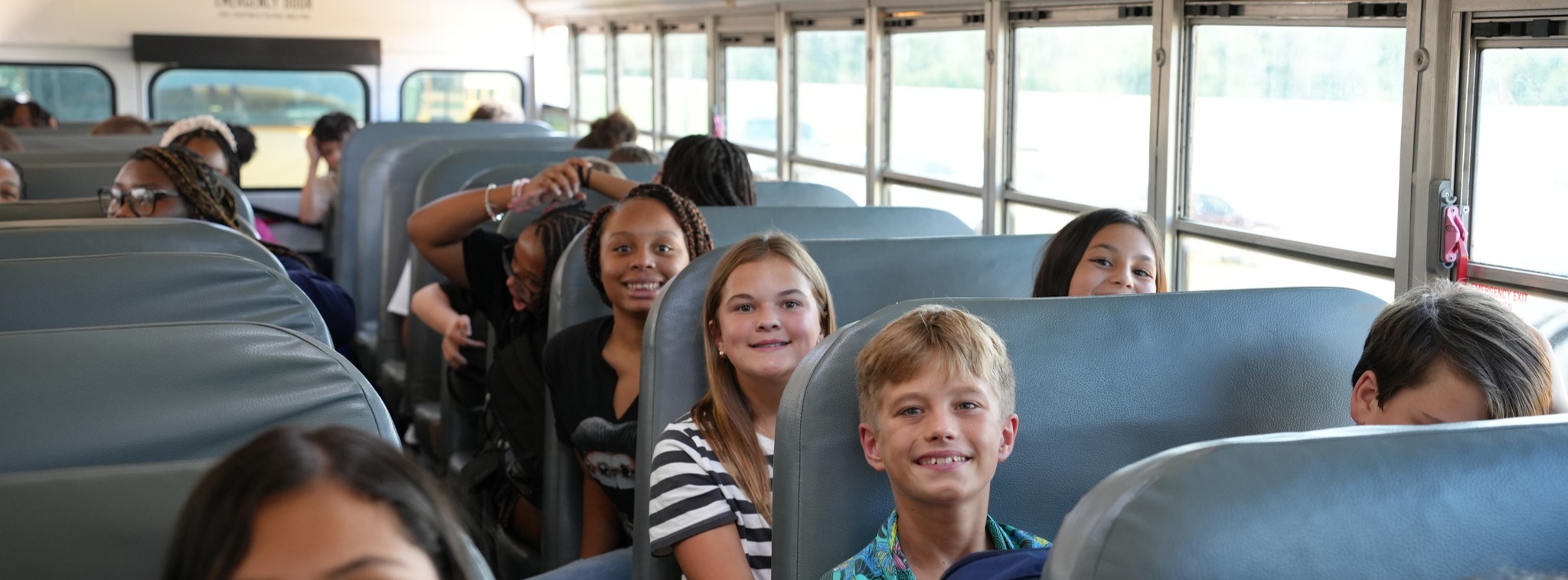 Students smiling on bus