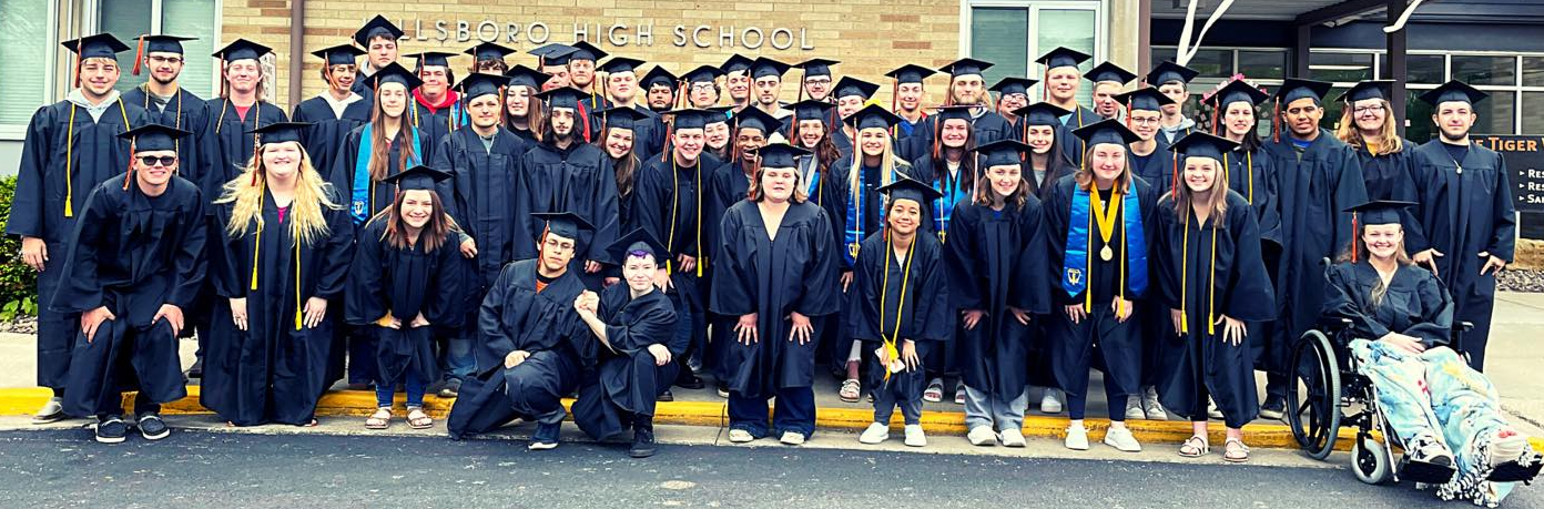 class of 2022 in caps and gowns outside school