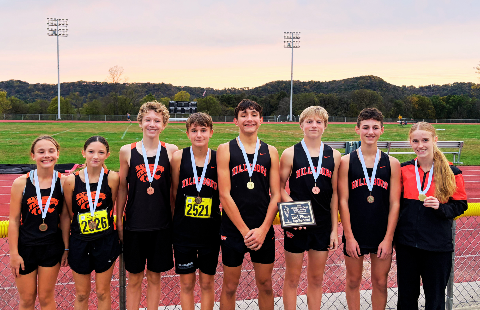 Middle and High School Cross Country pose with medals