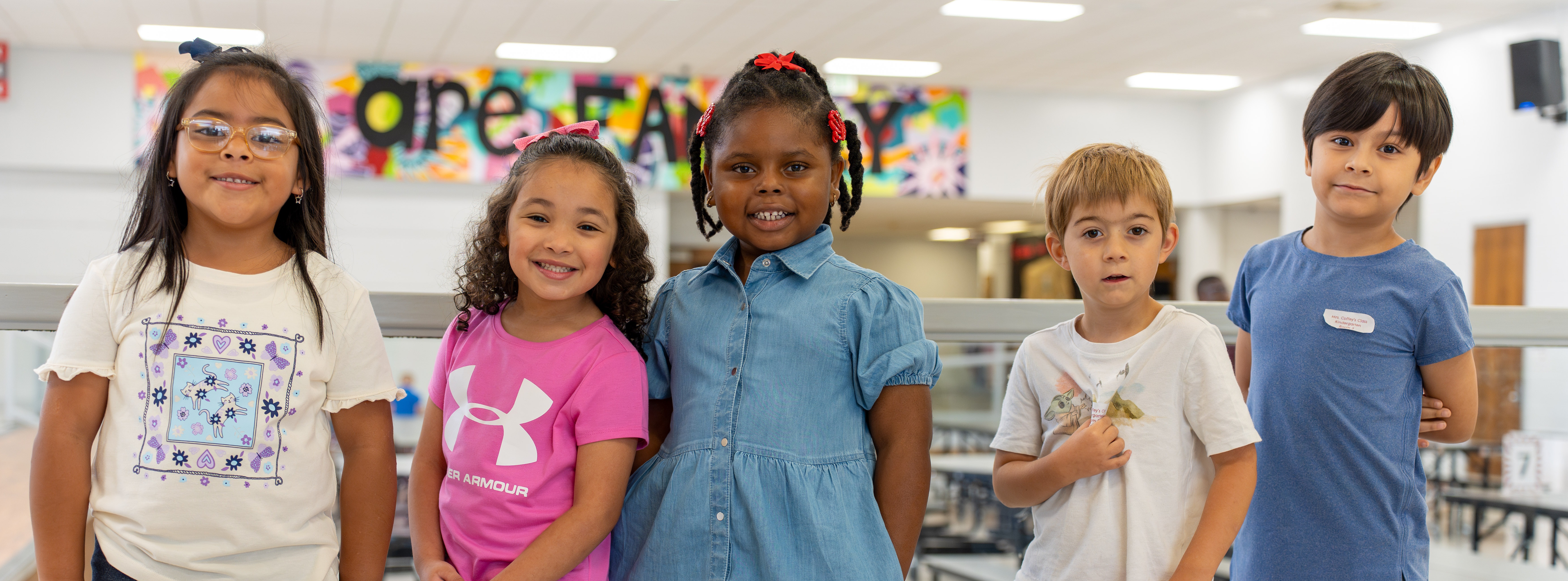 five students posing in lunchroom