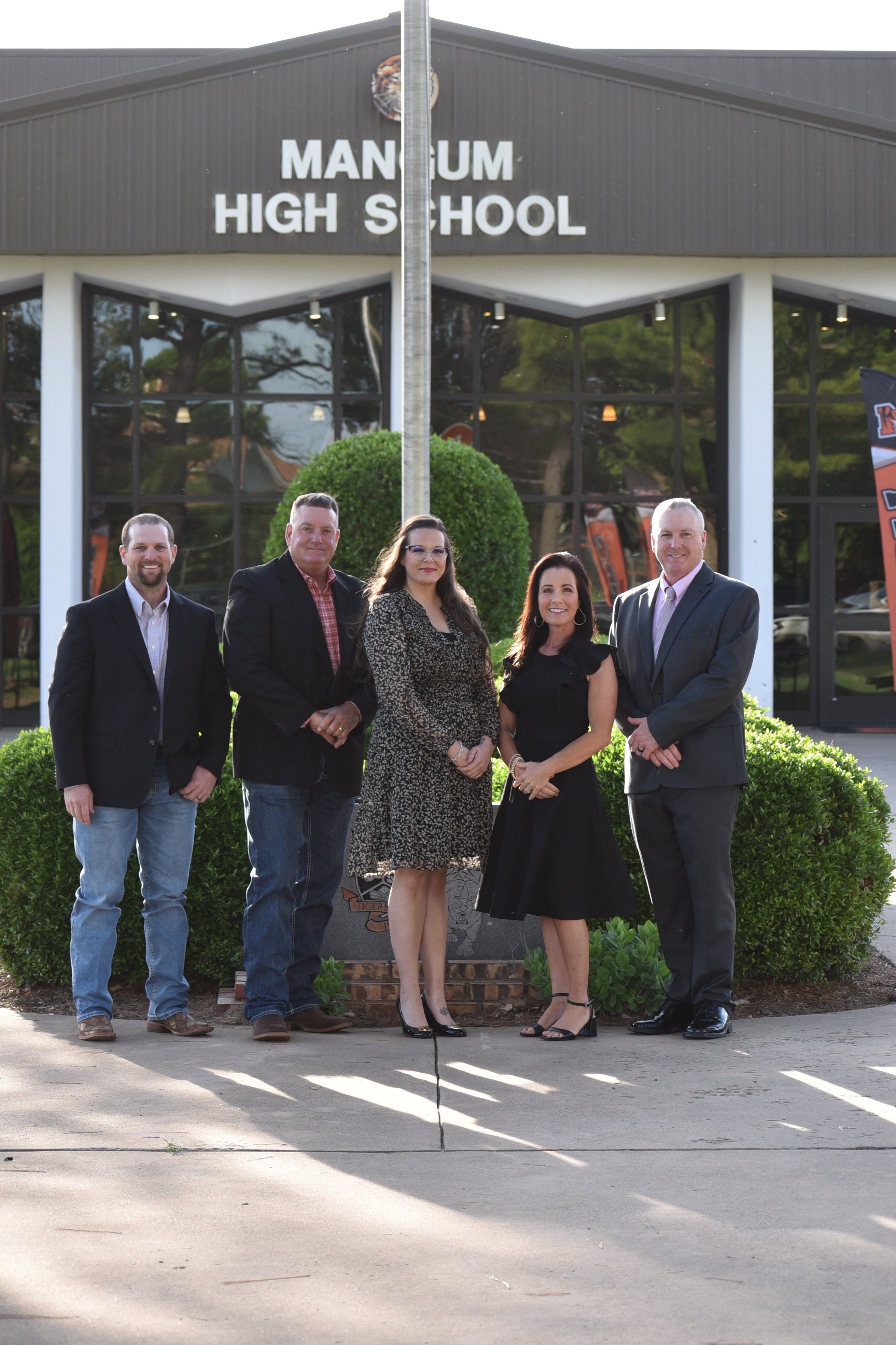 Board of education members standing in front of the high school 