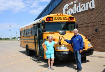 Transportation staff standing in front of a bus