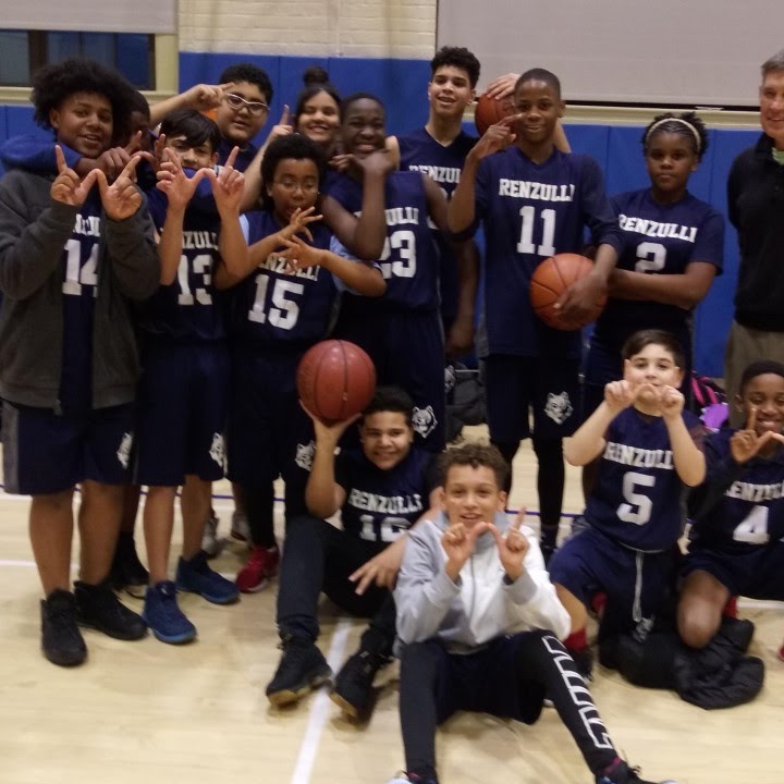 basket ball students all posing in the gym with basketballs 