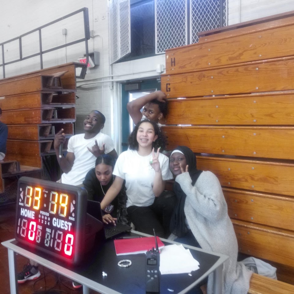 behind the score board/table area with student and parents