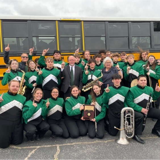 group of band students posing in front of bus