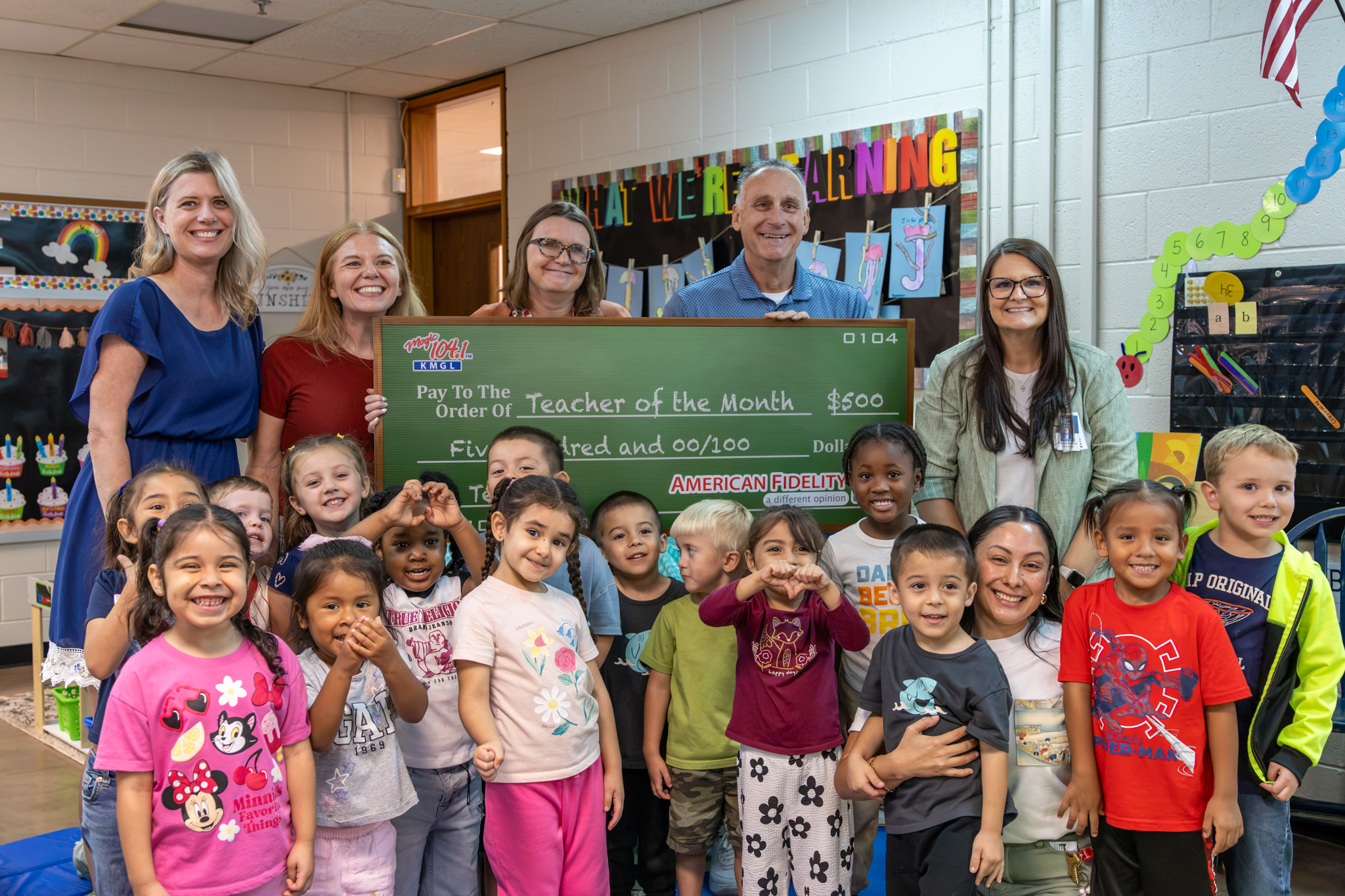 Lake Park Teacher Kristal Cantwell poses with her students, administration, and a giant check for winning Magic 104.1's Teacher of the Month