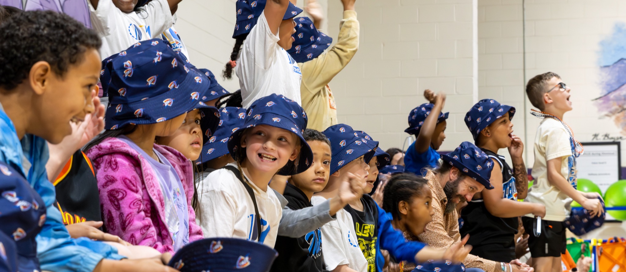Students sitting in bleachers jump up to cheer with excitement