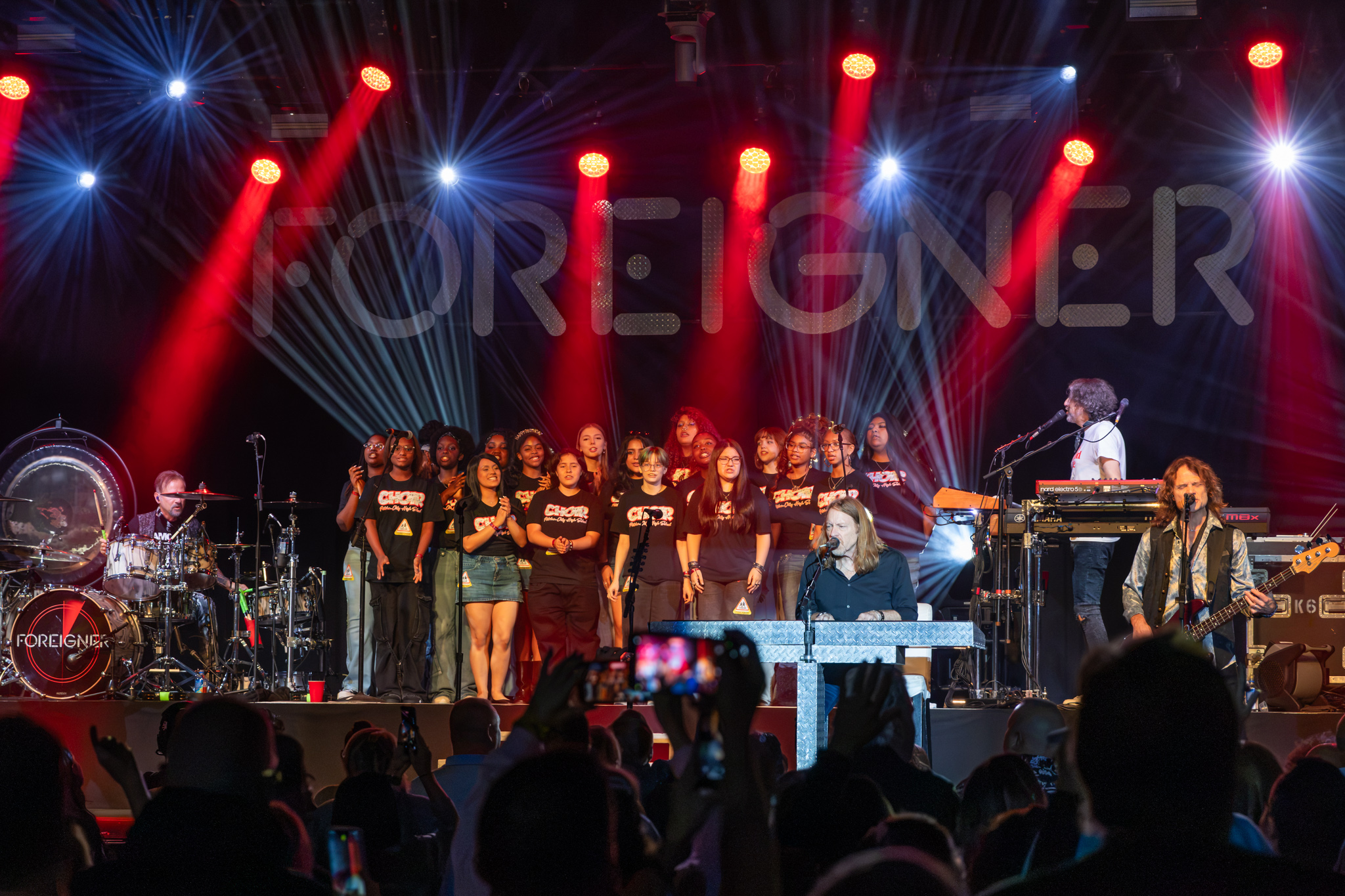 Members of PC High's Choir perform on stage with the band Foreigner