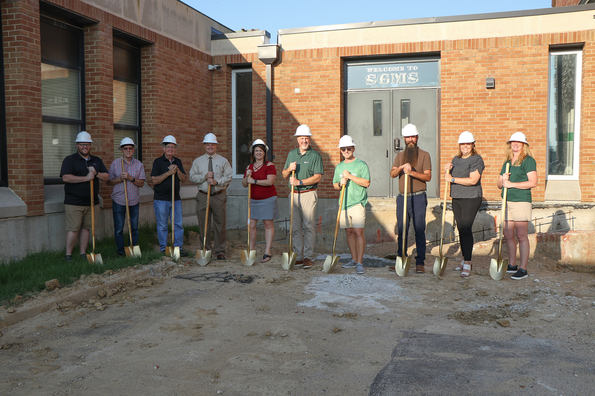 Board members, administrators and facility committee members take a photo with shovels.
