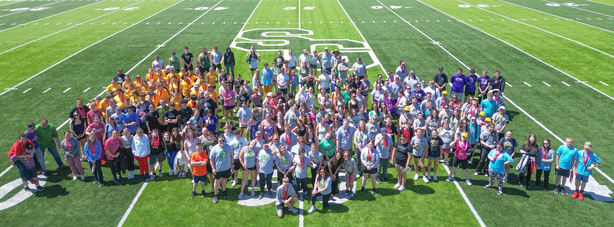 A group of students and staff take a group photo at the Unified Track Meet.