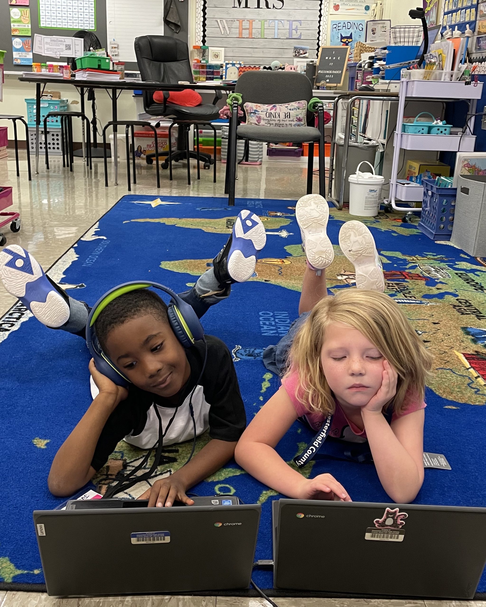 Two kids using laptops.