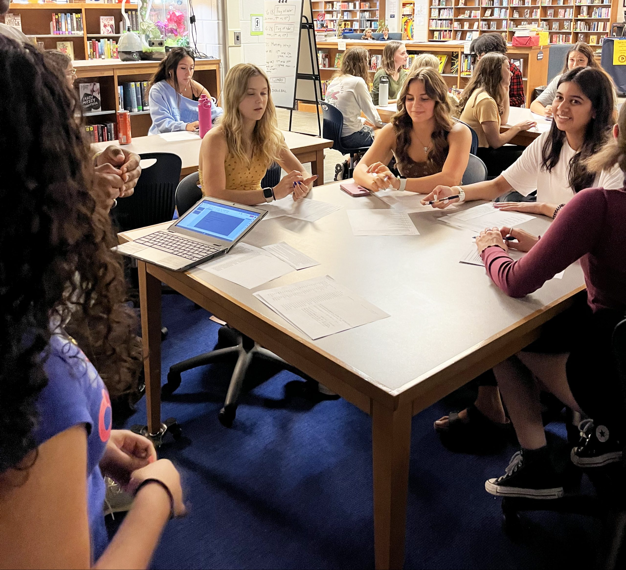 Several students at a table in the library working together.