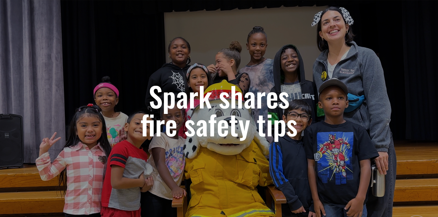 Sparky the Fire Dog taking a photo with a group of students