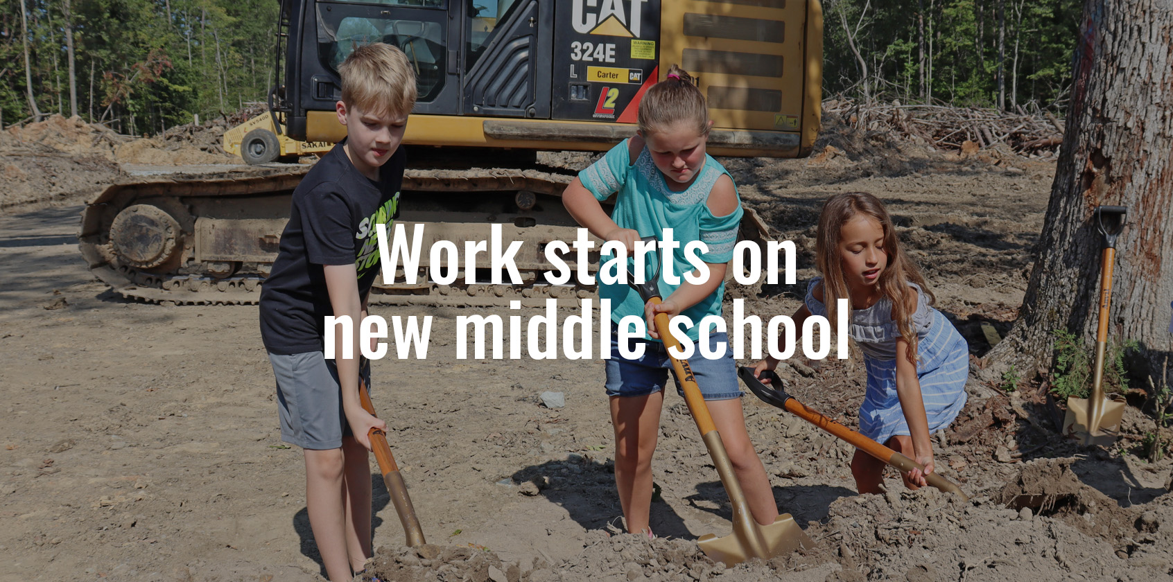 Three students shoveling dirt