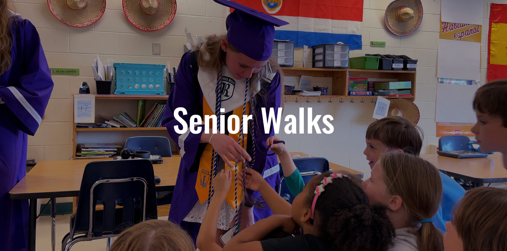 Elementary school students touching the graduation regalia of a James River High School student as she does her senior walk.