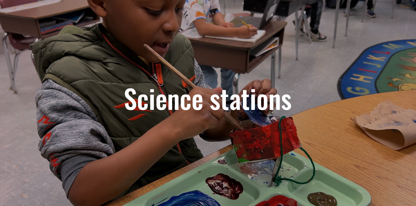 A student is painting a milk carton in class