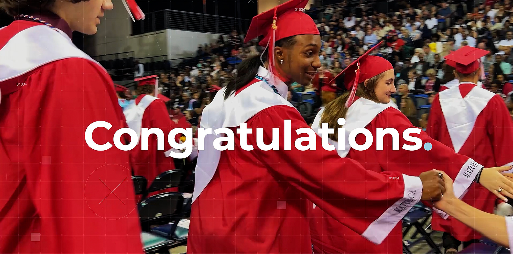 Graduates dressed in cap and gown shake hands with teachers.