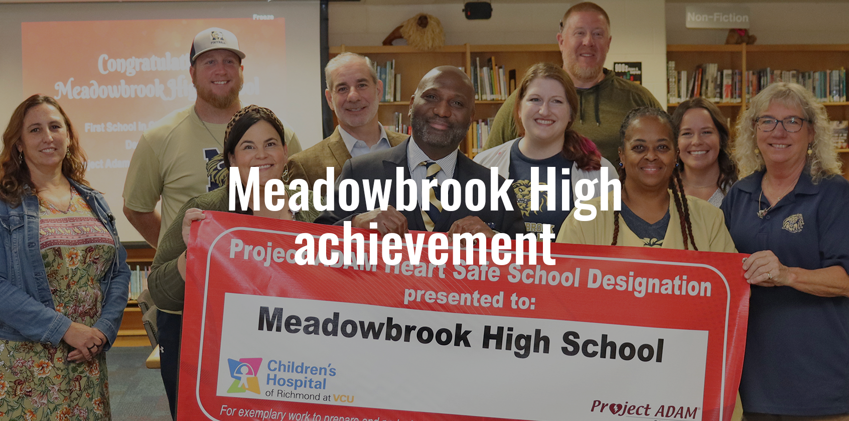 Staff members and students holding a recognition banner. Text says "Meadowbrook High achievement"