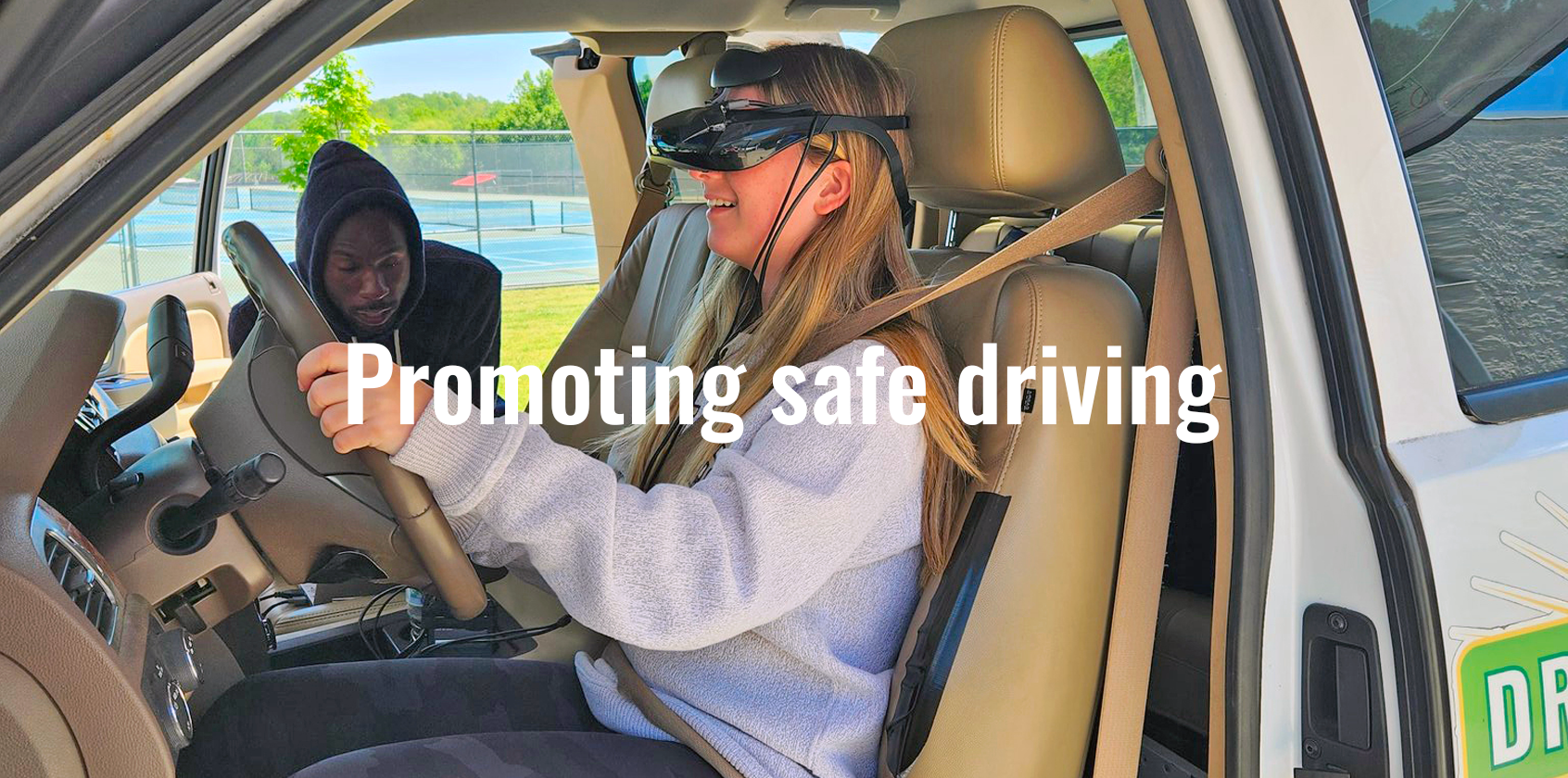 teenage driver behind the wheel wearing goggles for simulation