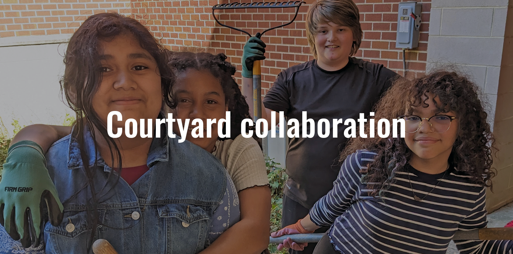 Four students pose for a picture while some are holding gardening tools