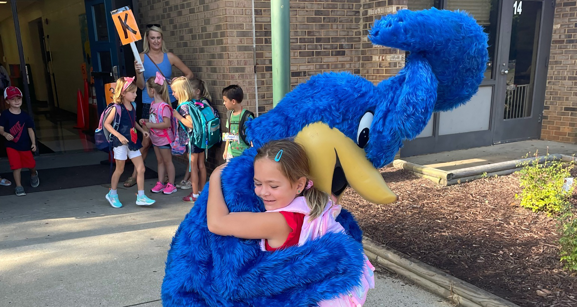 Student hugging Rocky mascot