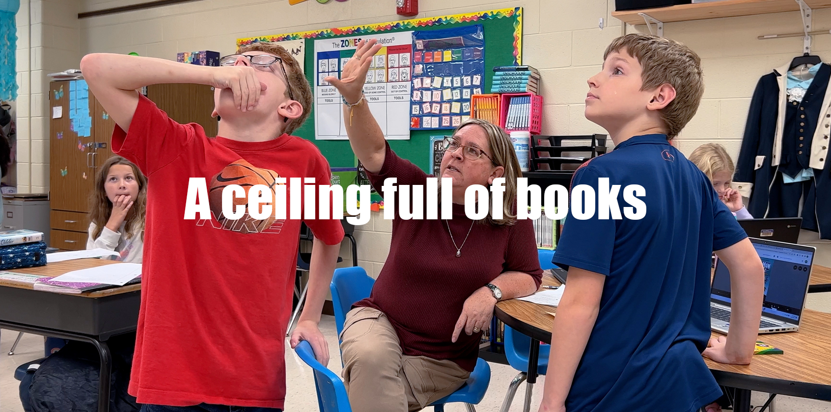 Teacher and students looking up at the ceiling.