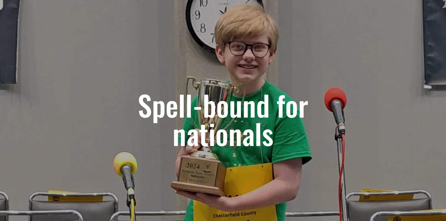 A student holding a trophy with text that says "Spell-bound for nationals"
