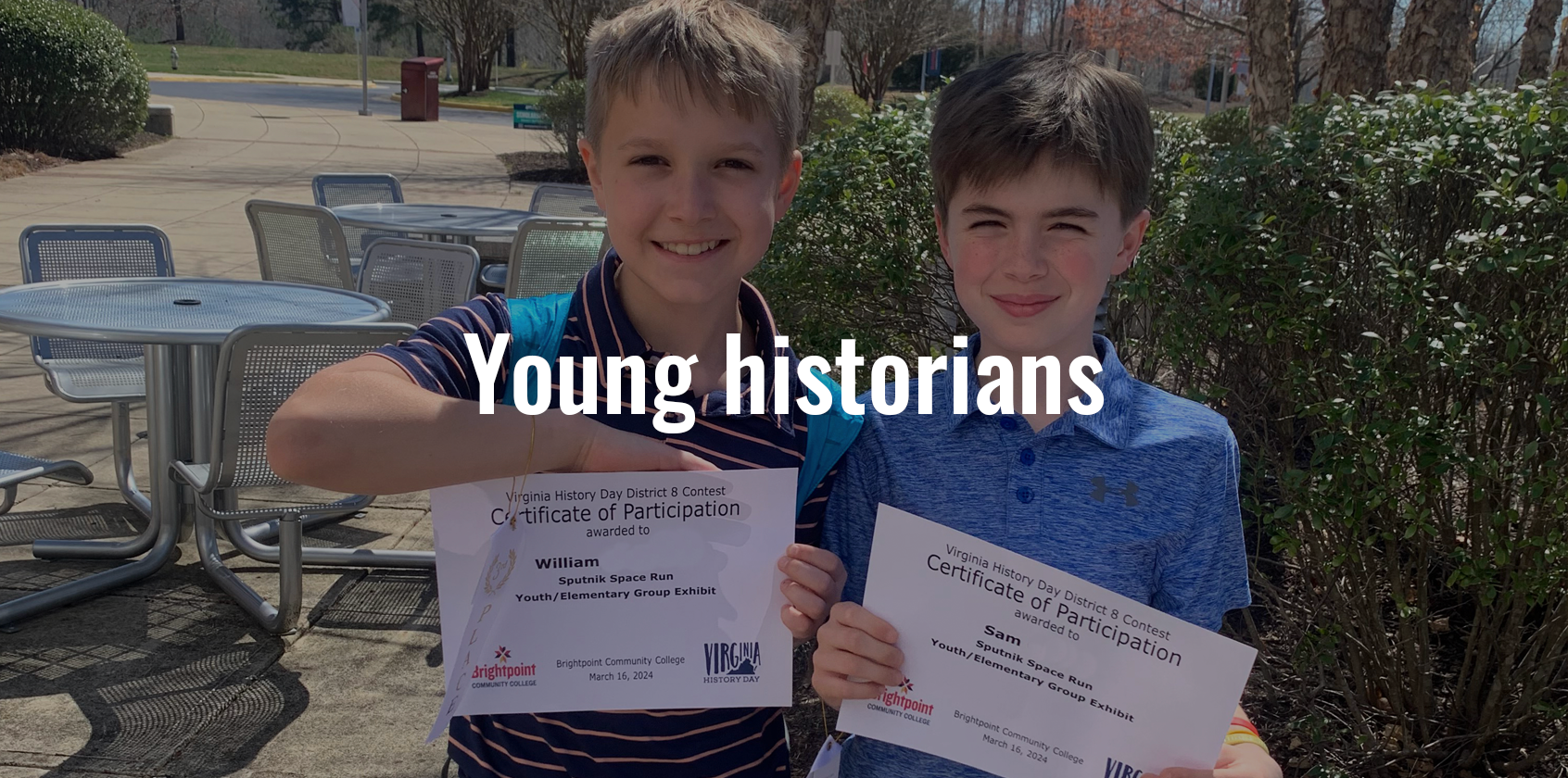 Two boys holding up a certificate outside and text that says "Young historians"