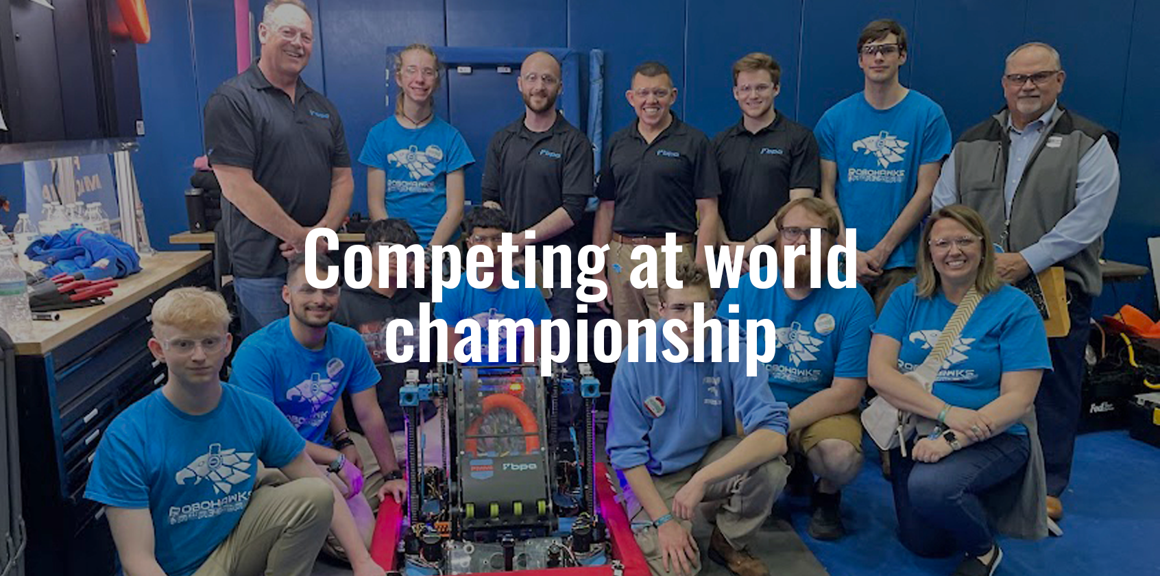 Robotics team posing for a photo in front of their robot