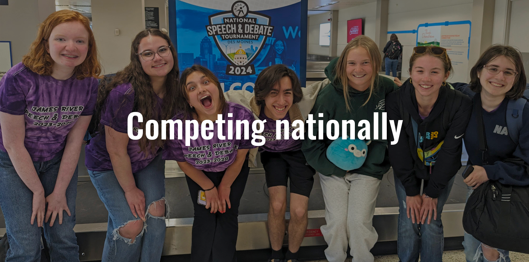 A group of students posing for a photo at the airport
