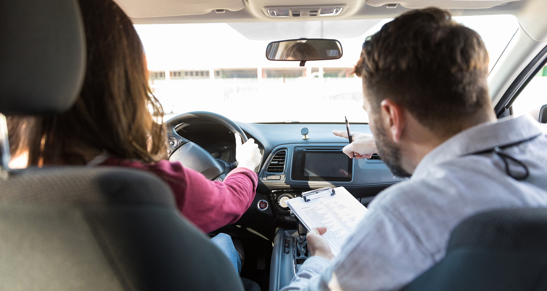 Student behind the wheel with teacher instructing in passengers seat