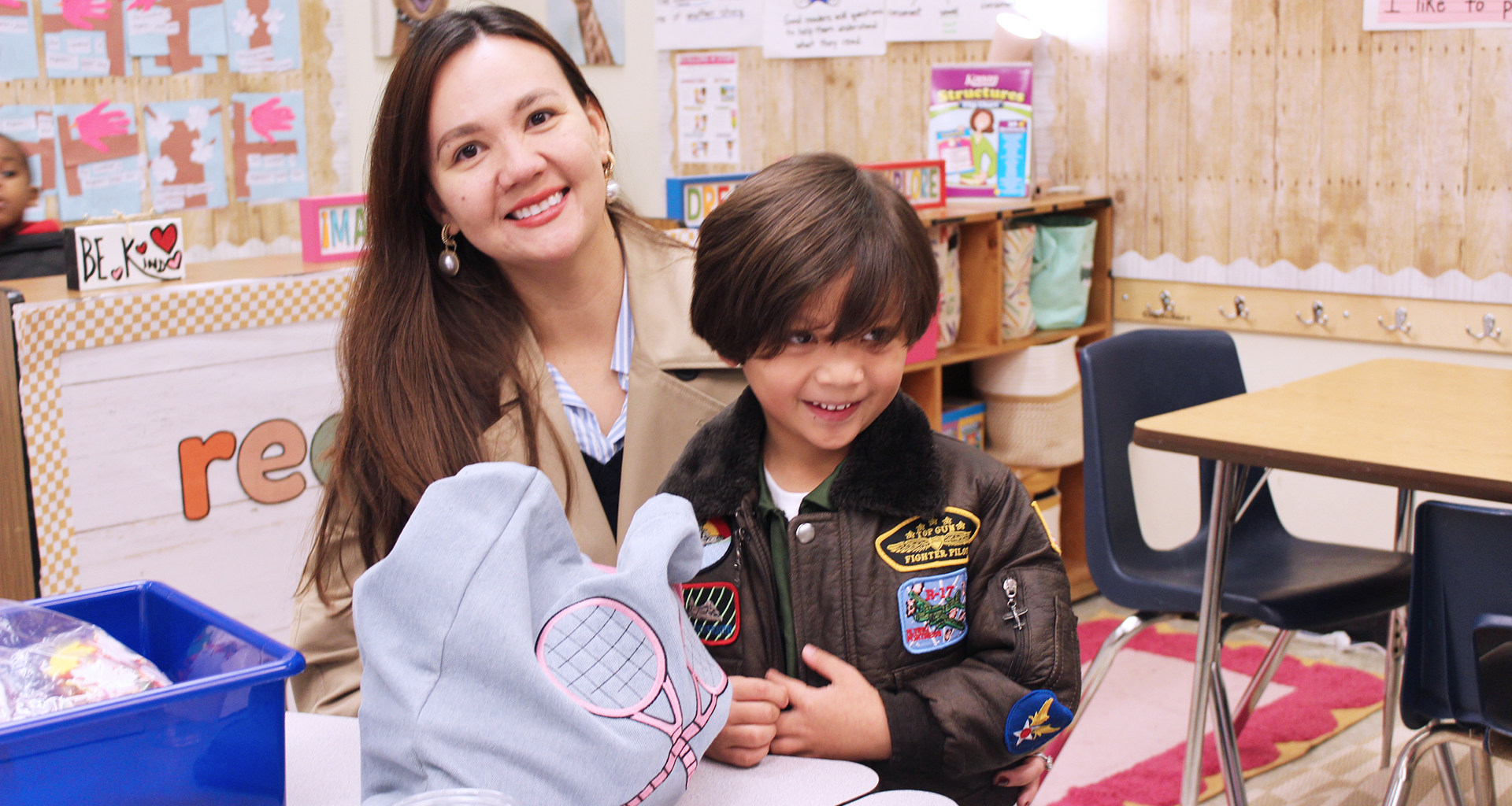 Parent smiles sitting with young student