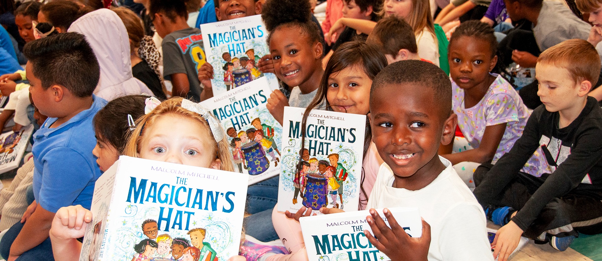 Students hold up their new books