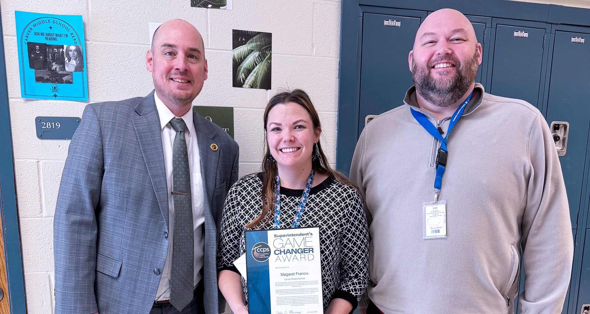 Teacher of the year standing with the principal, superintendent, and a school board member 