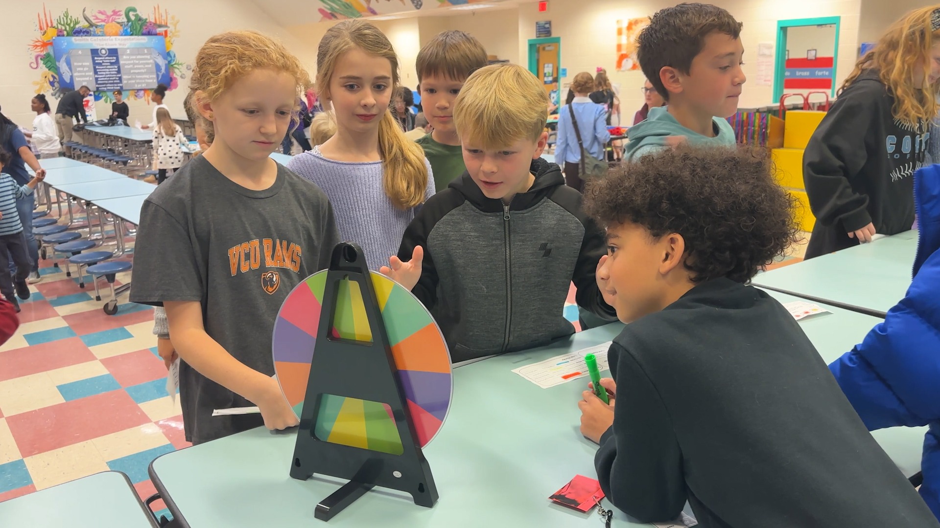Students gathered around a colorful wheel
