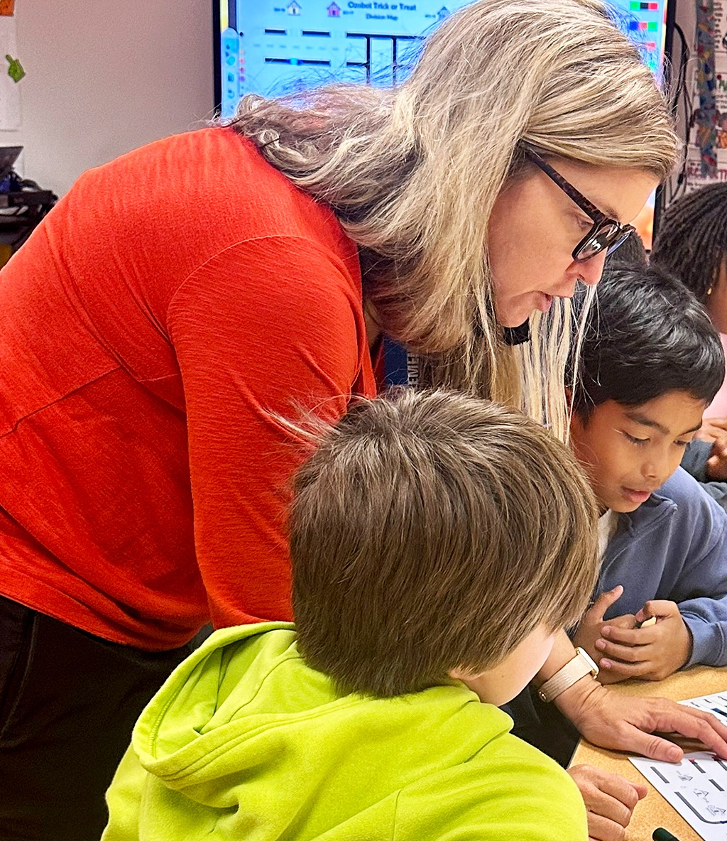 teacher helping two students