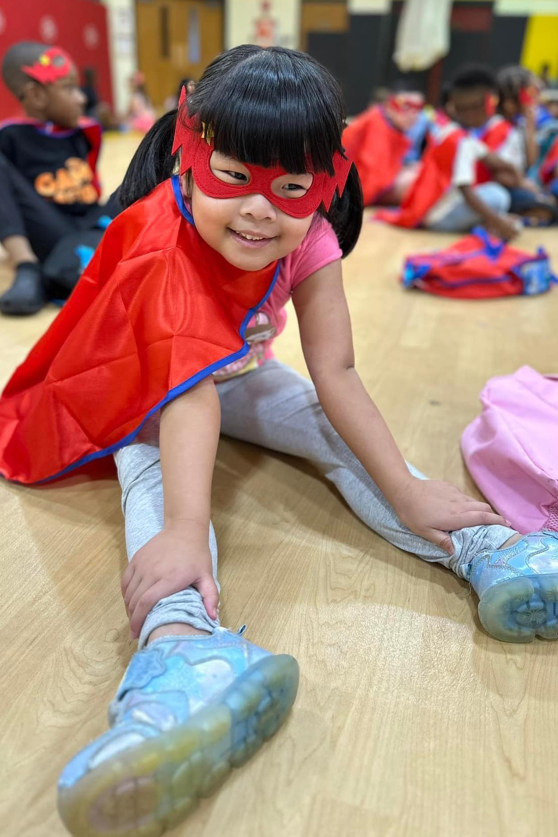 student wearing superman cape and mask