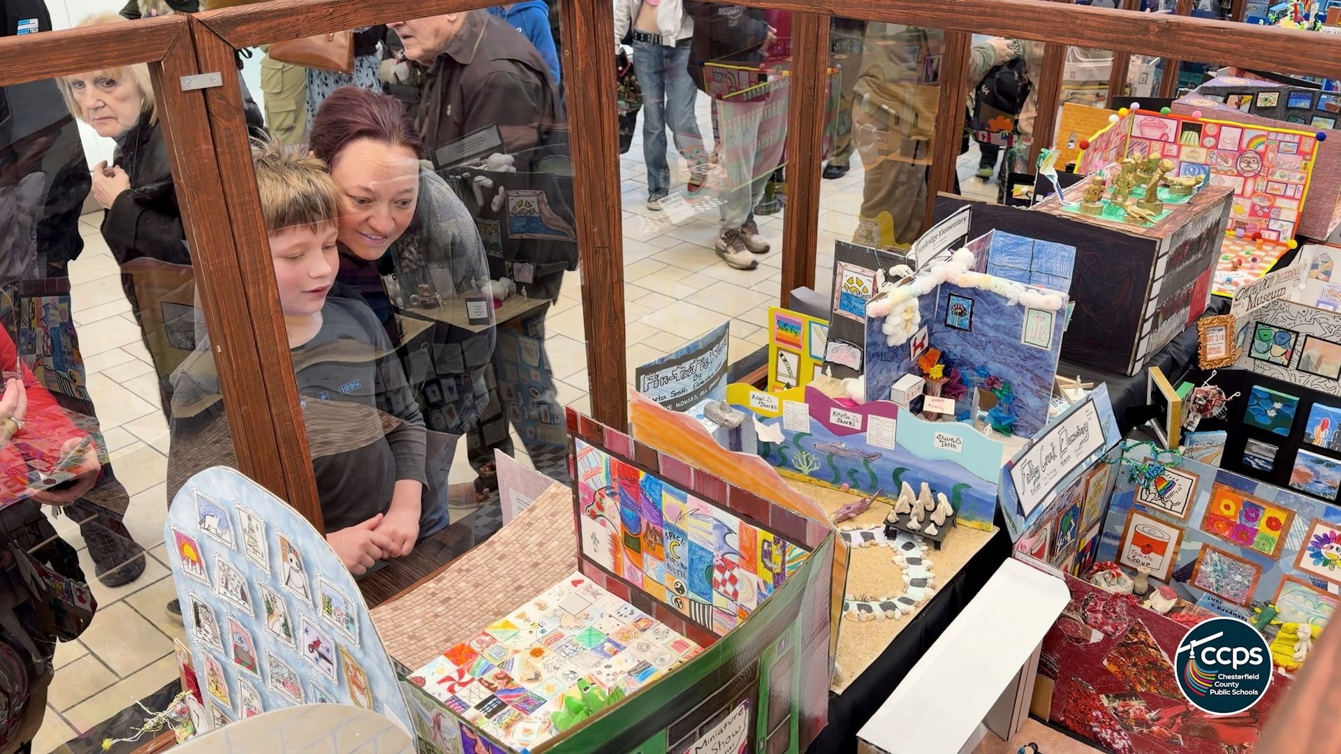 Families looking at mini art displays