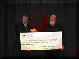 William Wartmann presents a check to Dr. Norman L. Fjelstad, Superintendent of the School District of Edgerton.